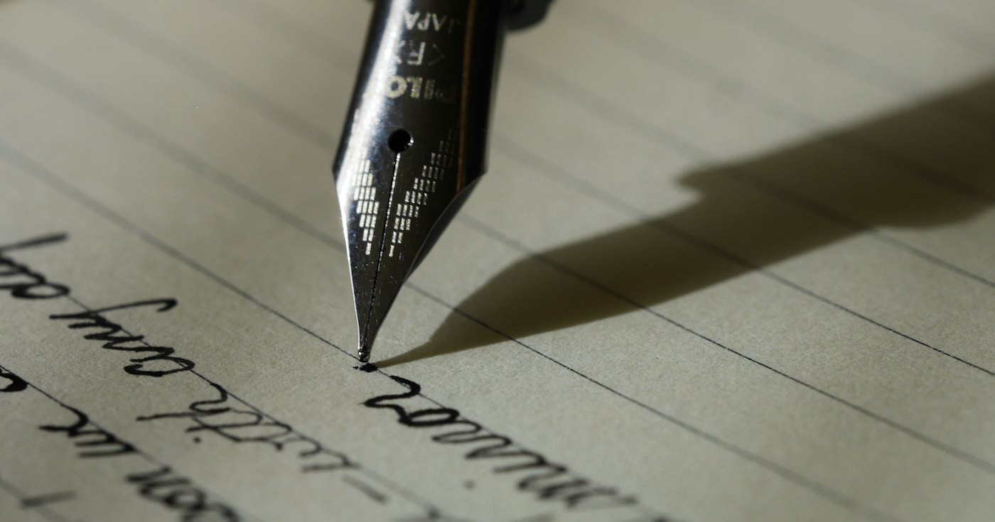 A fountain pen resting on lined paper