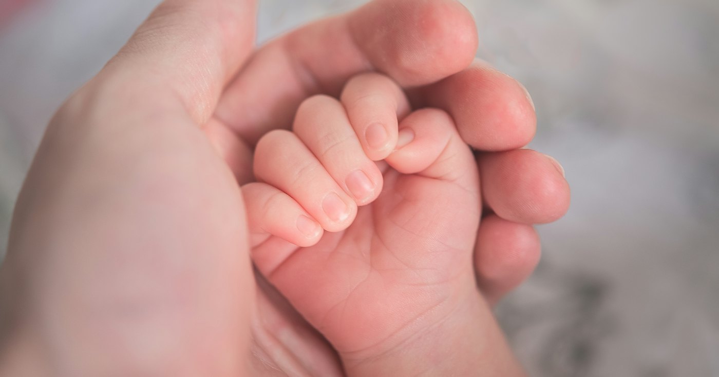 An adult holding a small child's hand