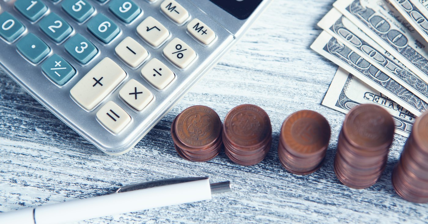 Calculator, pen and cash on a table