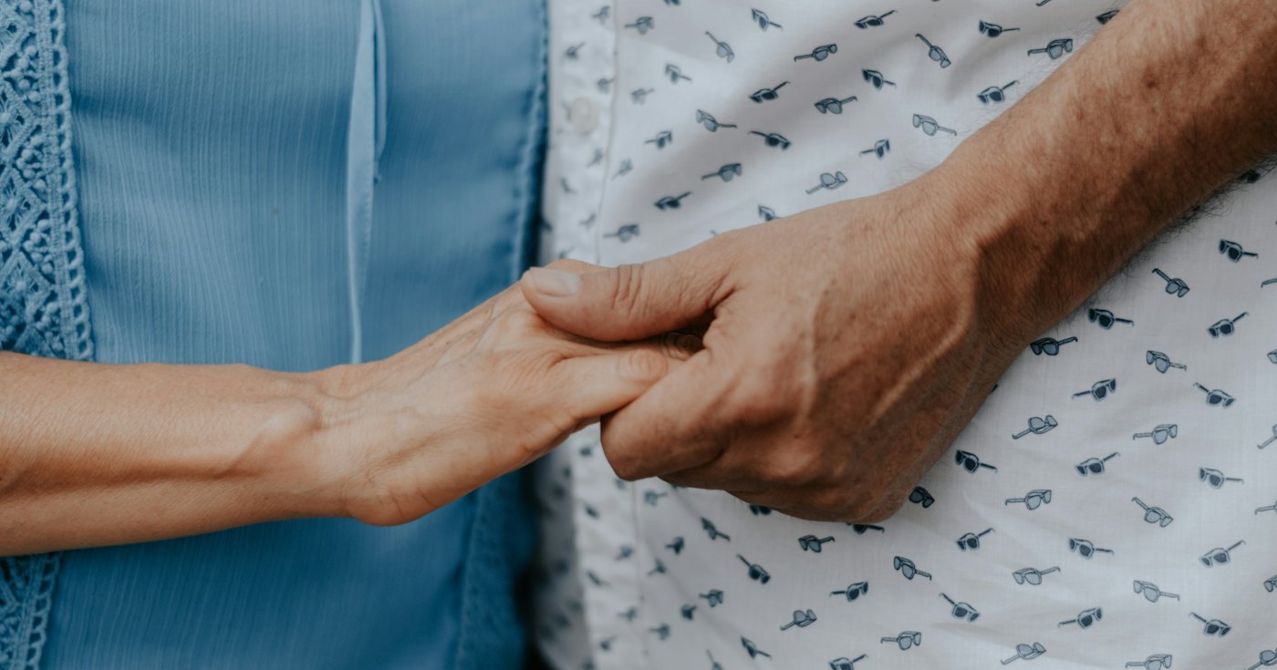 Two people holding hands in support