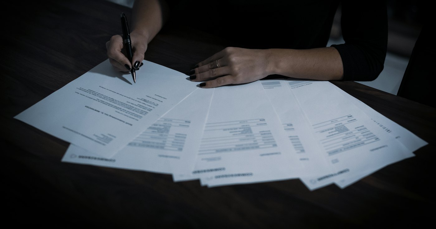 A woman reviewing a table covered with papers