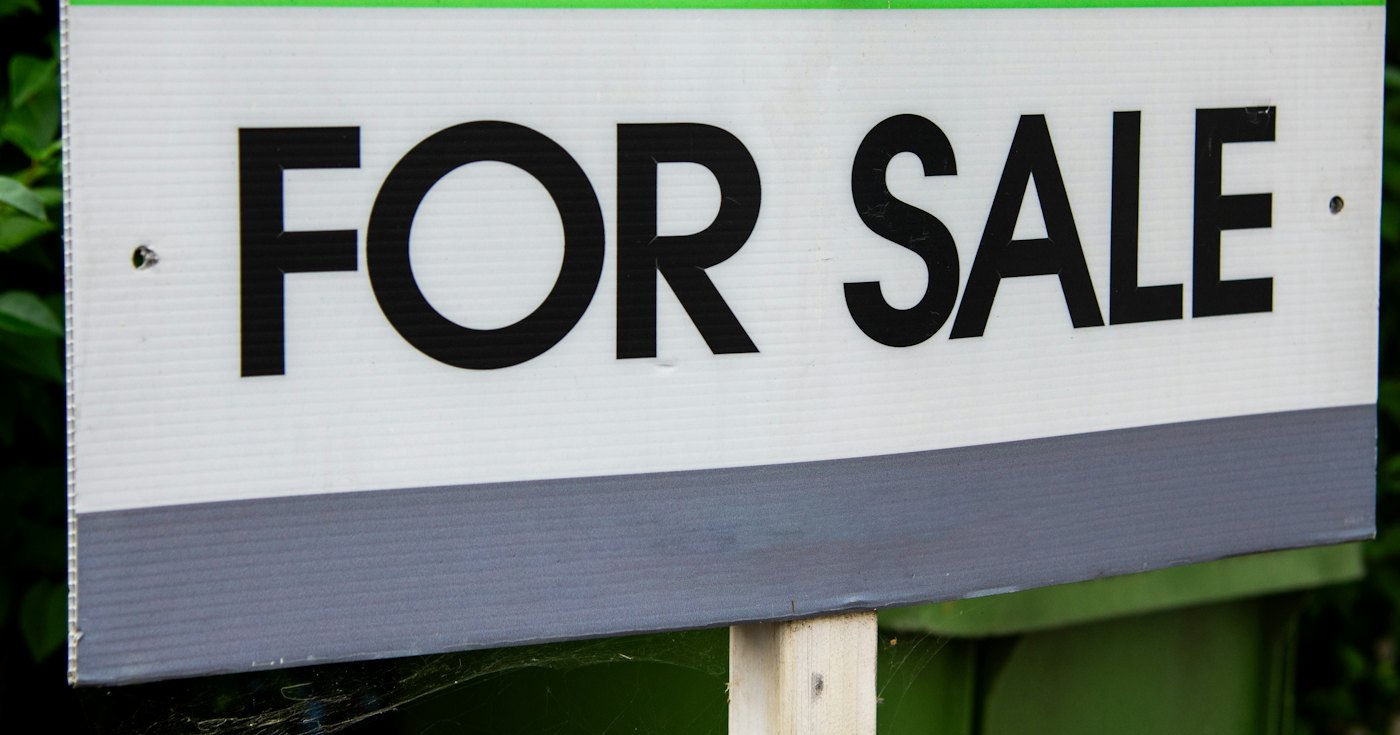 A for sale sign in front of a home